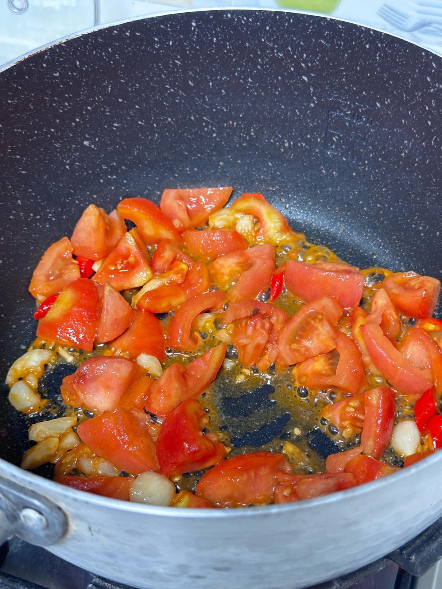 Stir-fry the aromatics, then add the tomatoes and cook for about one minute.