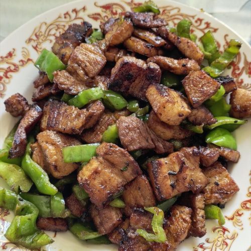 Twice-cooked pork huiguorou with crisp green peppers in a wok