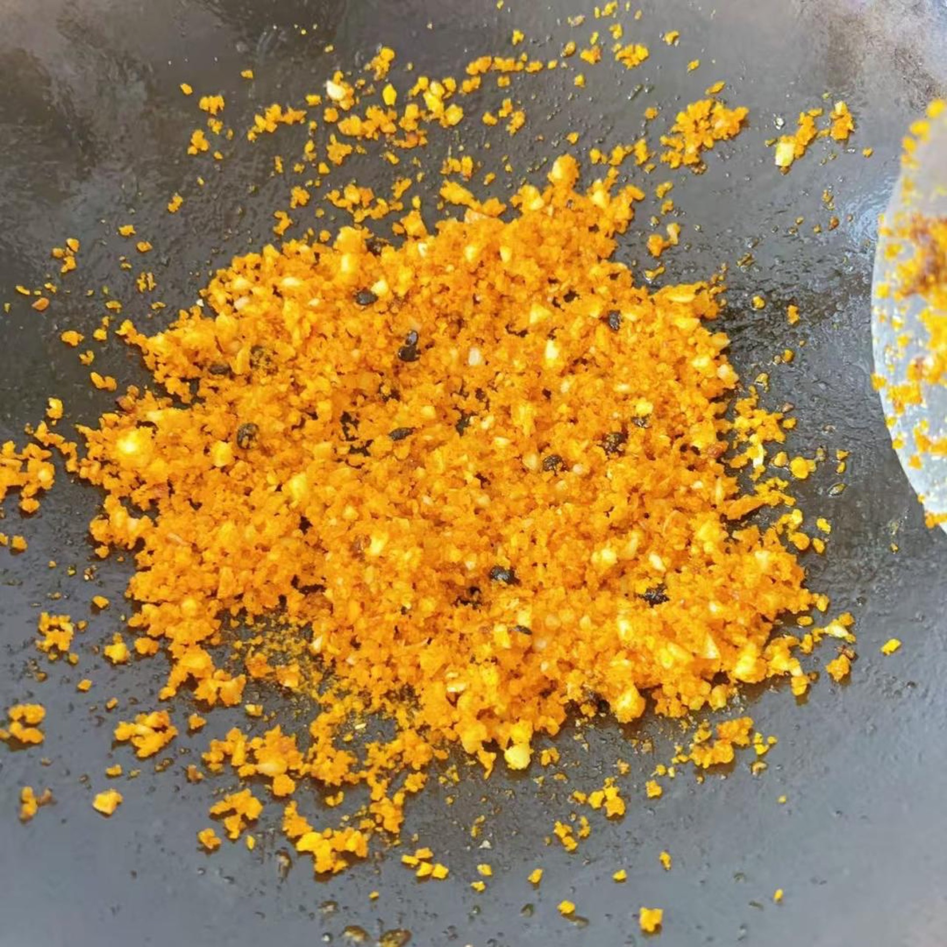 Add 1 ladle of typhoon shelter fried garlic mix to the pan and stir-fry over low heat until fragrant.