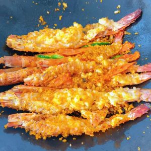 Add the prawns to the pan and toss everything together so the typhoon shelter mix coats the prawns evenly.