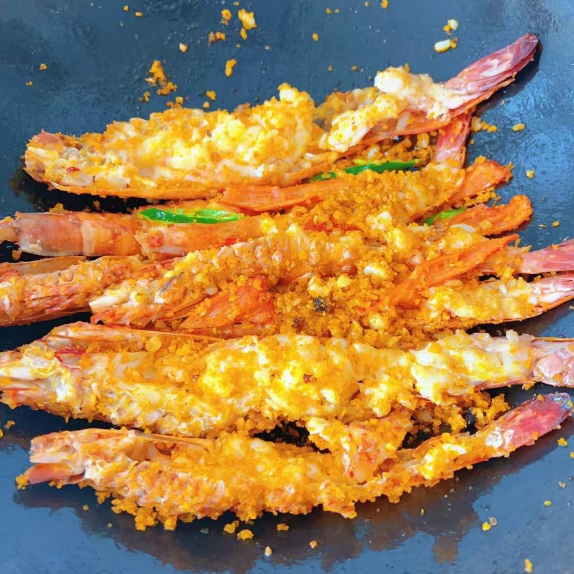 Add the prawns to the pan and toss everything together so the typhoon shelter mix coats the prawns evenly.