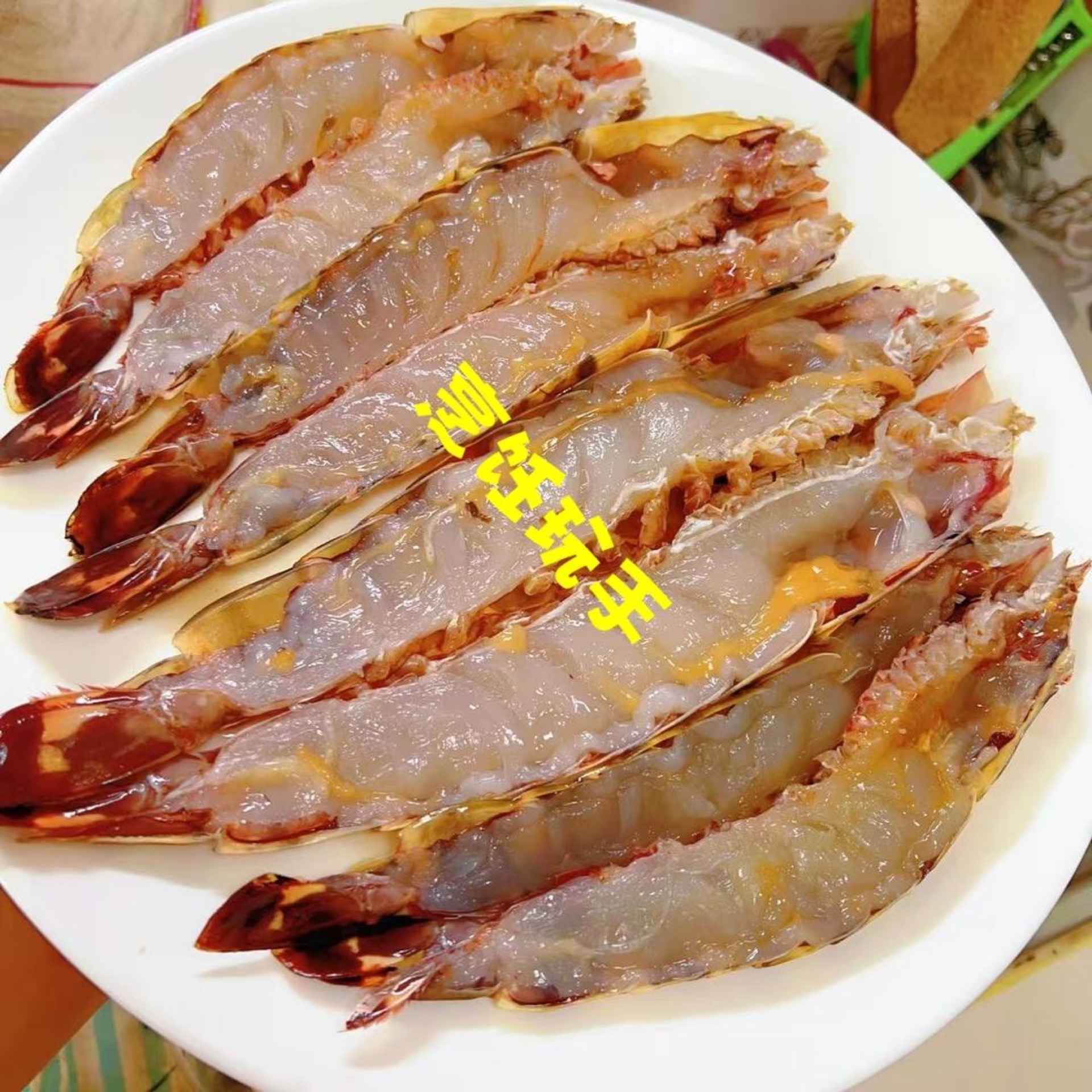 First, clean the prawns: snip off the antennae, legs and rostrum, cut open the hard shell down the middle with kitchen shears, then split each one in half with a knife, remove the