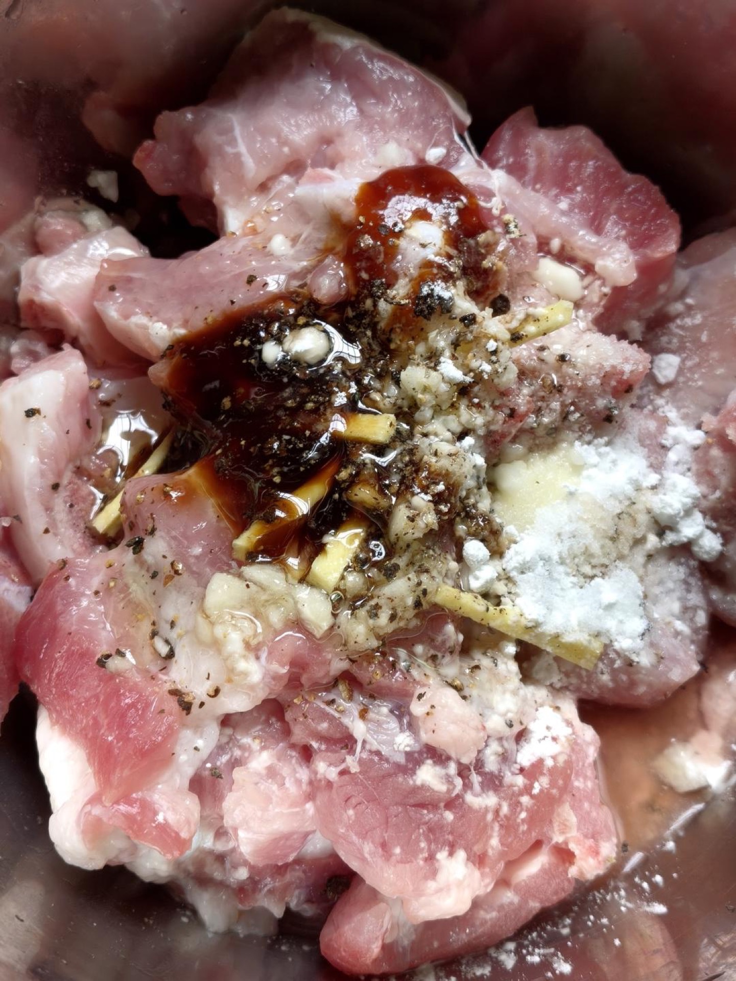 Put the drained ribs in a bowl, add the cornstarch, oyster sauce, salt, oil, black pepper, ginger, and garlic, and stir everything together until every piece is evenly coated.