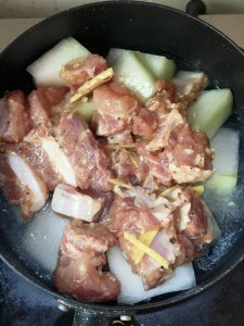 Lay the winter melon slices in an even layer in the bottom of a snow pan or small pot, pour in one bowl of water, spread the marinated ribs flat on top, then bring it to a boil ove