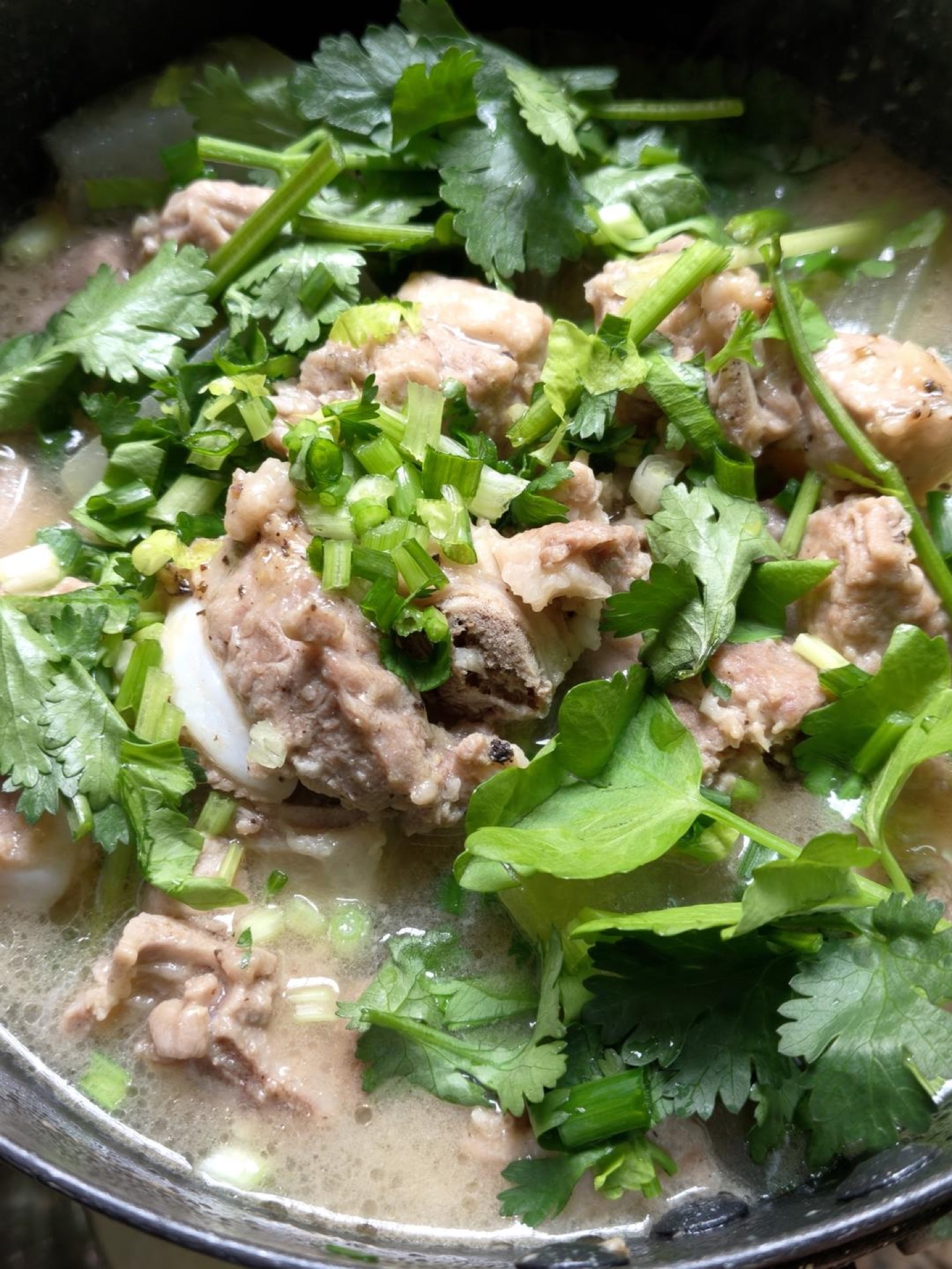 Turn off the heat, scatter the celery, scallion, and cilantro over the top, stir everything together, and it is ready to come out of the pot.