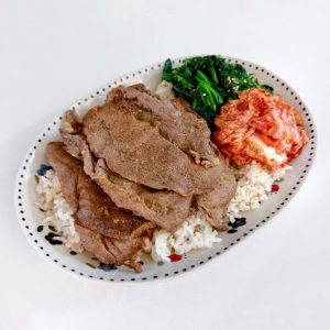 Arrange the spinach and kimchi on top of the rice, then lay the remaining beef slices over everything.