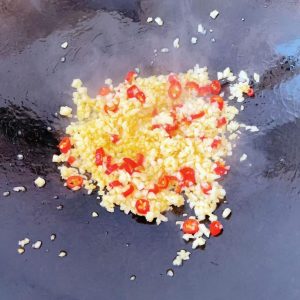 When the oil is hot, add the garlic and chili and stir-fry over low heat until fragrant.
