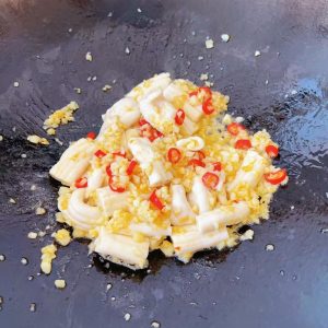 Add the beef marrow to the wok and stir-fry quickly.